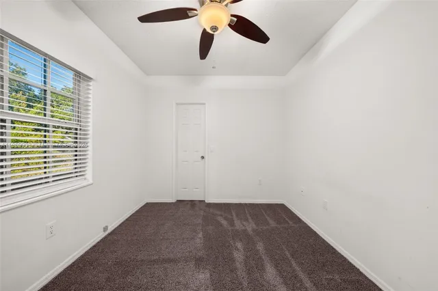 a view of a room with a ceiling fan and a window