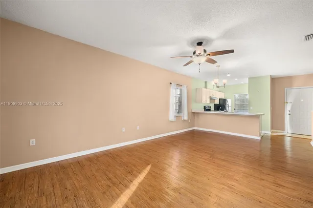 wooden floor in an empty room with a kitchen