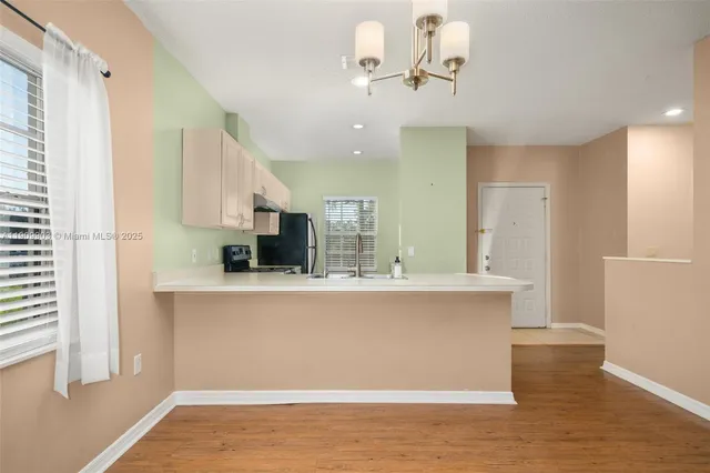 a view of kitchen with stainless steel appliances granite countertop cabinets and wooden floor