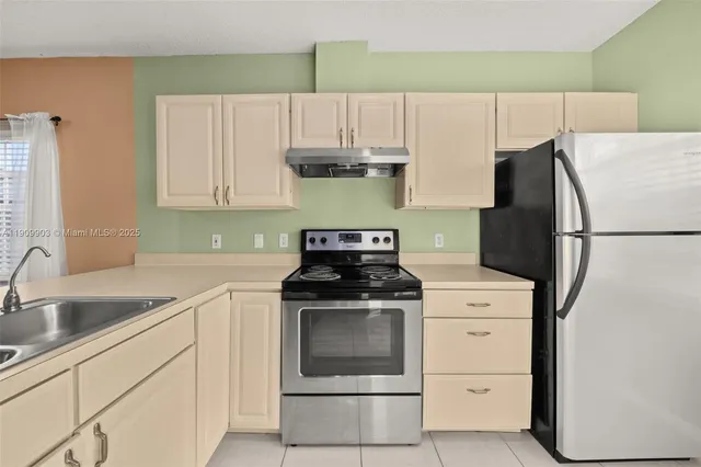 a kitchen with granite countertop a sink stove and refrigerator
