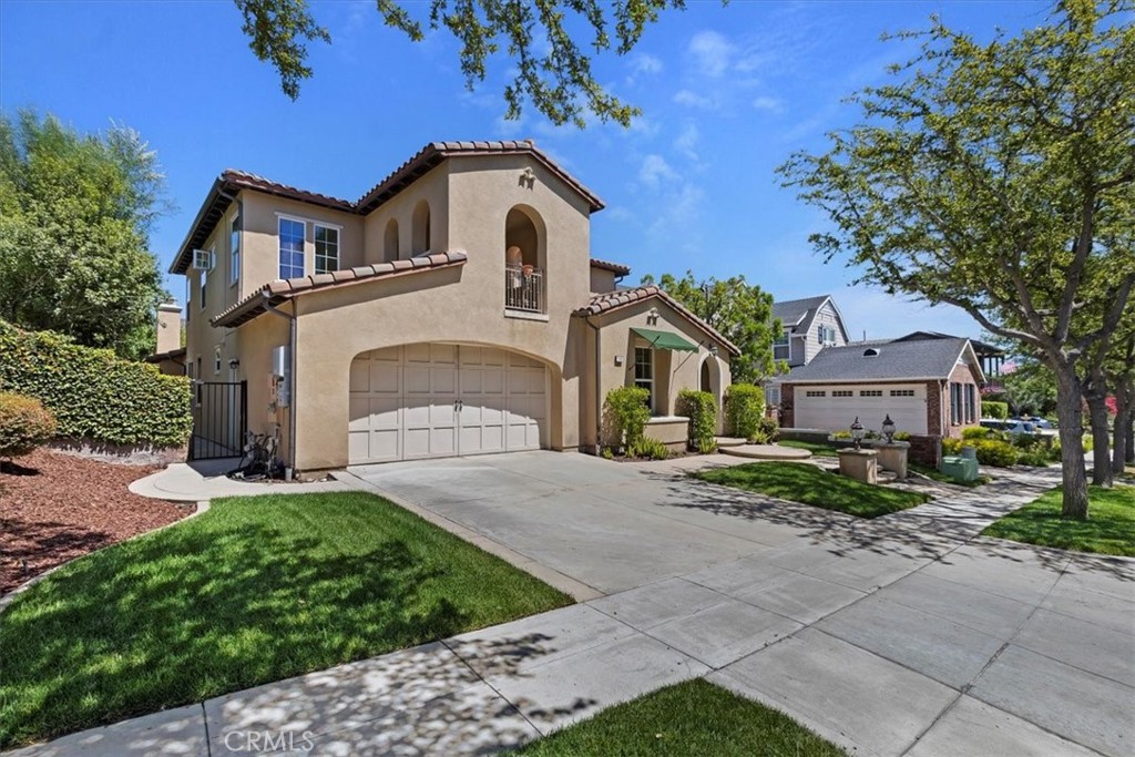 a front view of a house with a garden and trees
