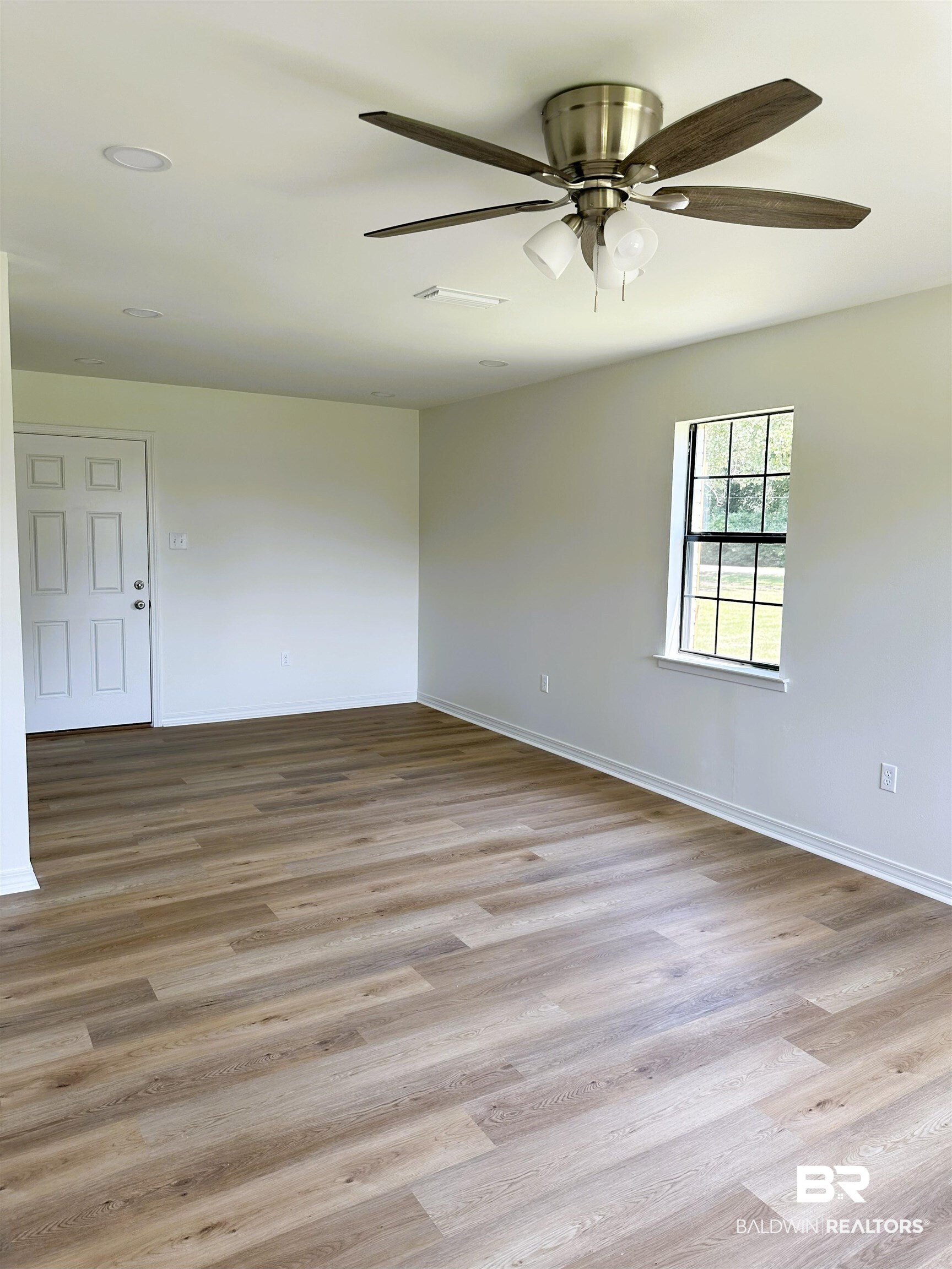 701 McRae Street Atmore, AL 36502 - Photo 2 of 11 Unfurnished room featuring light wood-type flooring and ceiling fan