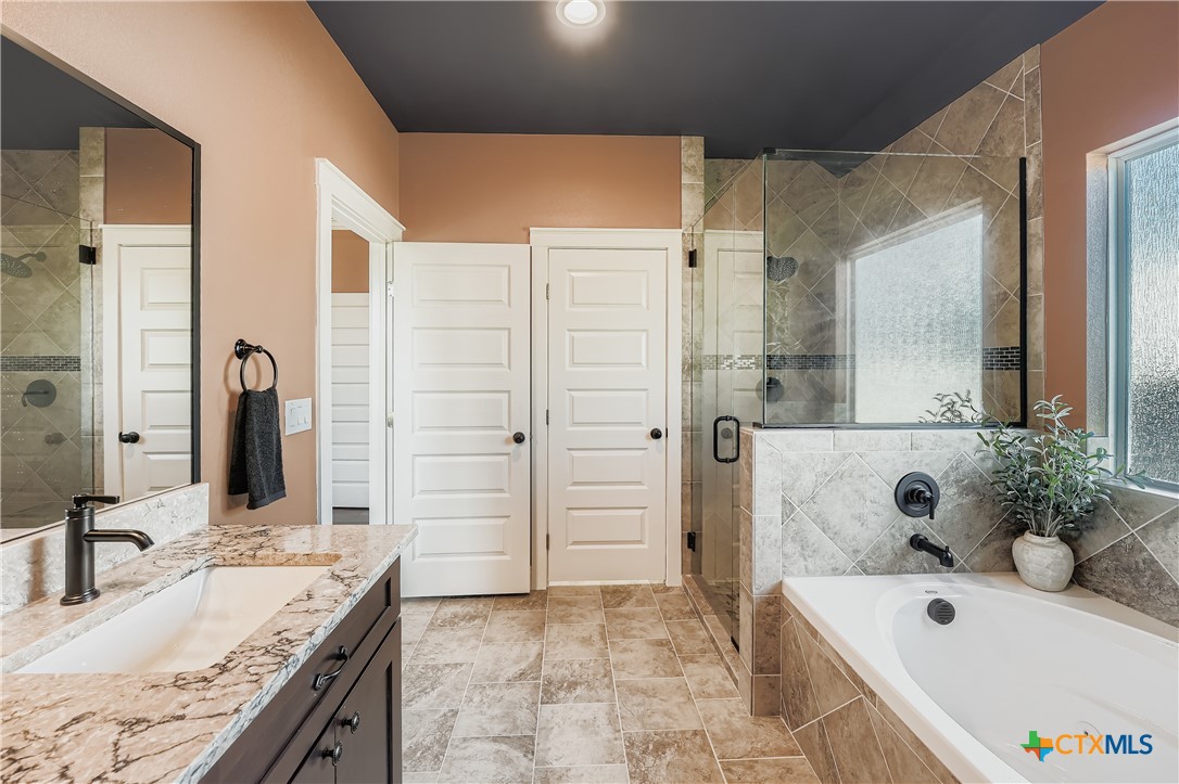 222 Arosa Drive Elgin, TX 78621 - Photo 26 of 40 a bathroom with a granite countertop tub sink and mirror
