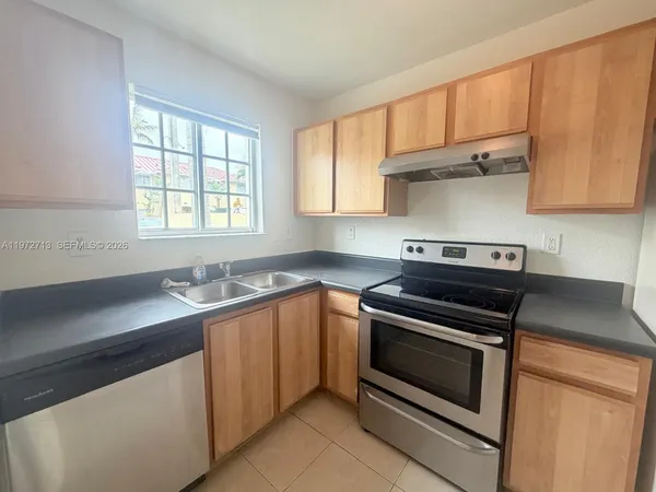 a kitchen with wooden cabinets stove top oven and sink