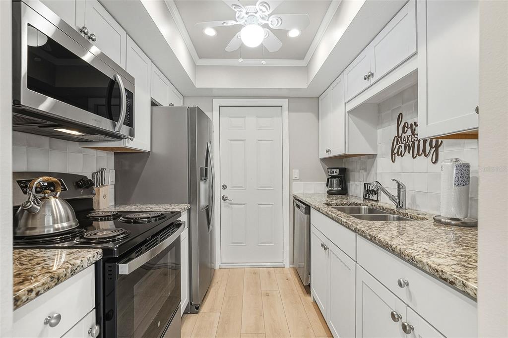 6300 Midnight Pass Road, Unit 21 Sarasota, FL 34242 - Photo 13 of 30 a kitchen with stainless steel appliances granite countertop a sink stove and refrigerator
