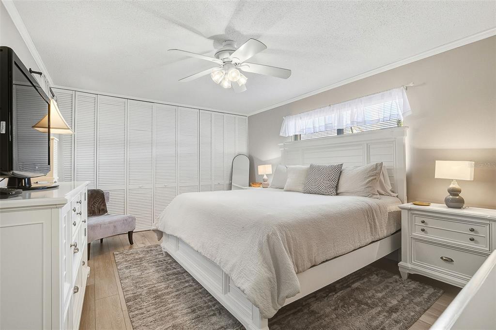 6300 Midnight Pass Road, Unit 21 Sarasota, FL 34242 - Photo 17 of 30 a bedroom with a large bed and a chandelier