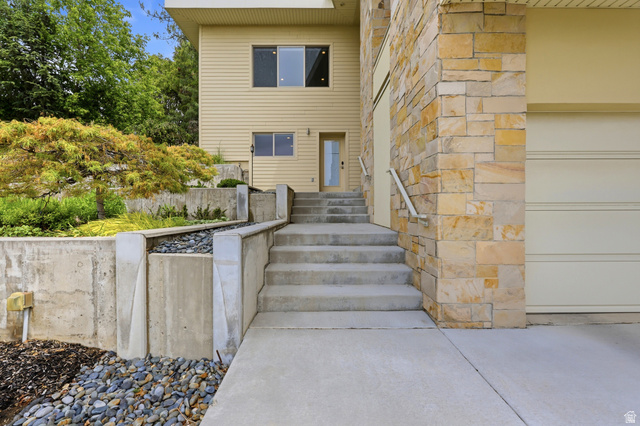 1389 Millbrook Way Bountiful, UT 84010 - Photo 10 of 74 Split-level residence featuring stone and siding exterior, concrete staircase, and integrated garage