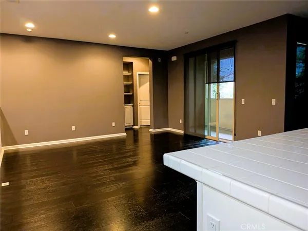 a kitchen with stainless steel appliances wooden floor and a refrigerator