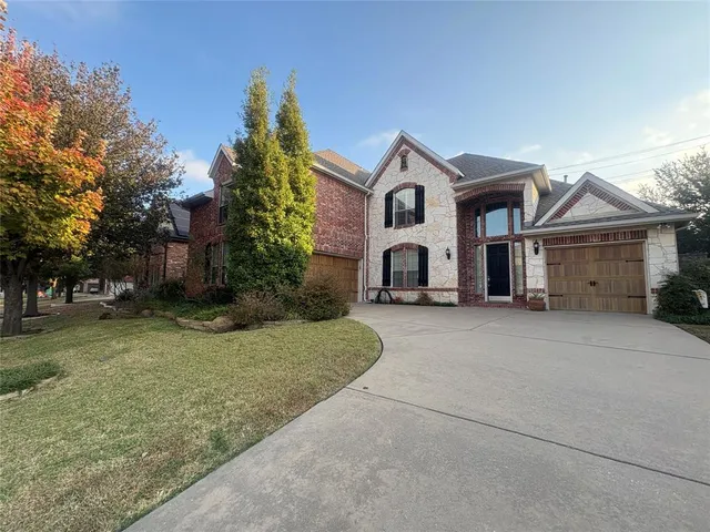 a view of a white house with a yard and large tree