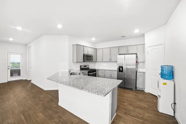 a kitchen with refrigerator and microwave