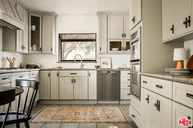 a kitchen with stainless steel appliances kitchen island granite countertop a sink and cabinets