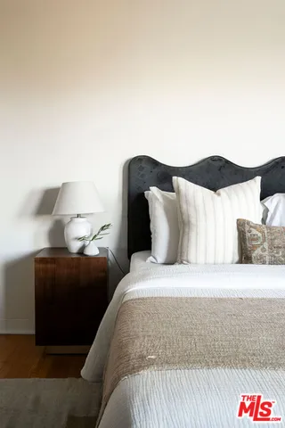 a large bed sitting in a bedroom next to a lamp