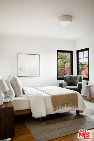 a bedroom with a bed and wooden floor