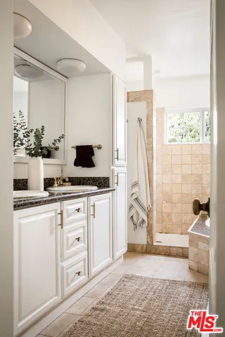 a view of kitchen with granite countertop cabinets and window