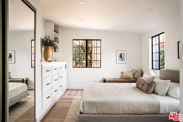 a bedroom with a large bed and a chandelier