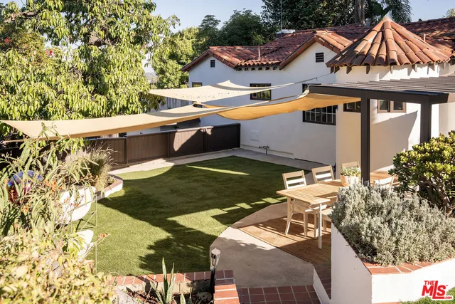 a view of a patio with table and chairs potted plants with wooden floor and fence