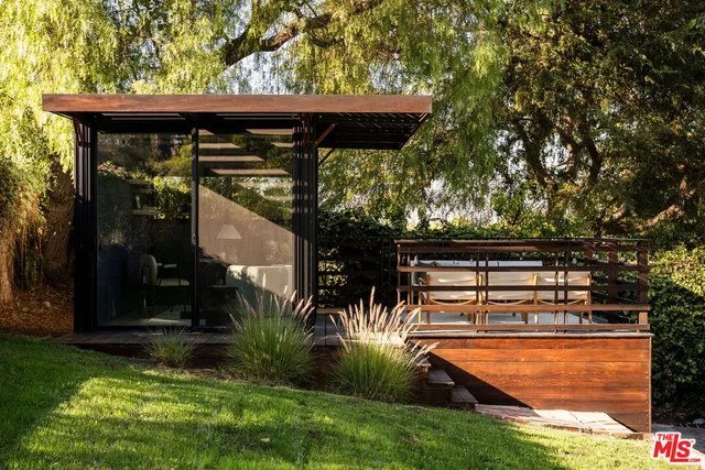 a patio with table and chairs and potted plants