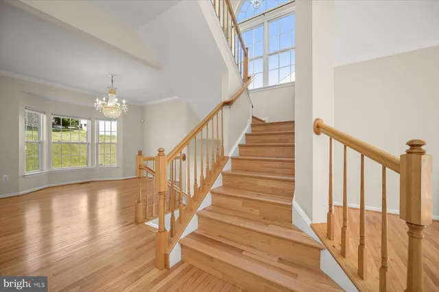 a view of staircase with wooden floor and white walls