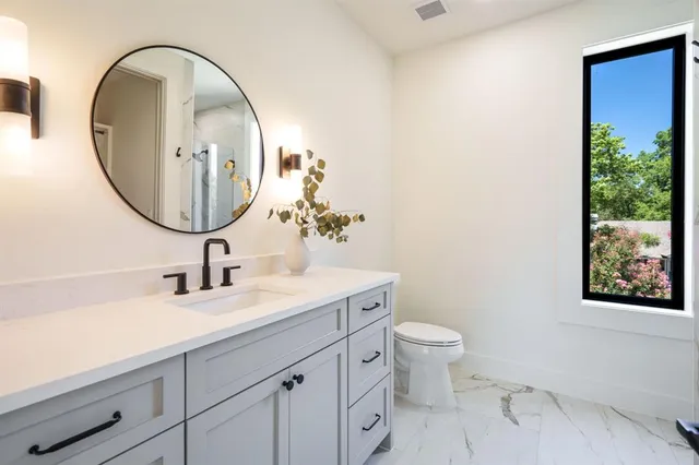 a bathroom with a toilet a sink and mirror