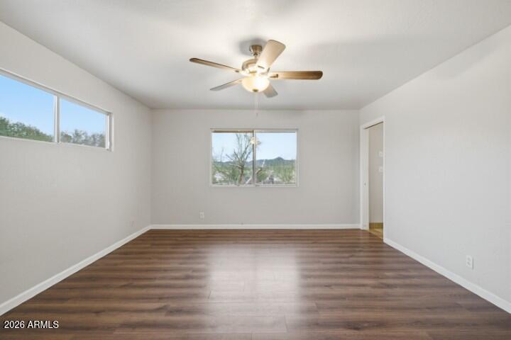19402 West Lynx Road Buckeye, AZ 85326 - Photo 26 of 42 an empty room with wooden floor chandelier fan and windows
