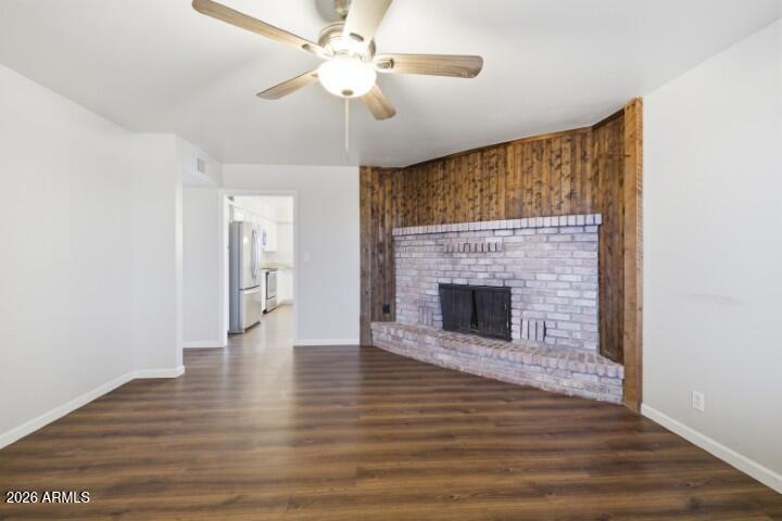 19402 West Lynx Road Buckeye, AZ 85326 - Photo 4 of 42 a view of a livingroom with a fireplace a ceiling fan and brick wall