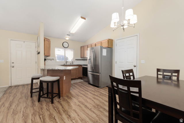 161 West 950 South, Unit S4 St. George, UT 84770 - Photo 7 of 21 Kitchen with stainless steel appliances, vaulted ceiling, a kitchen bar, a chandelier, and light wood-style floors