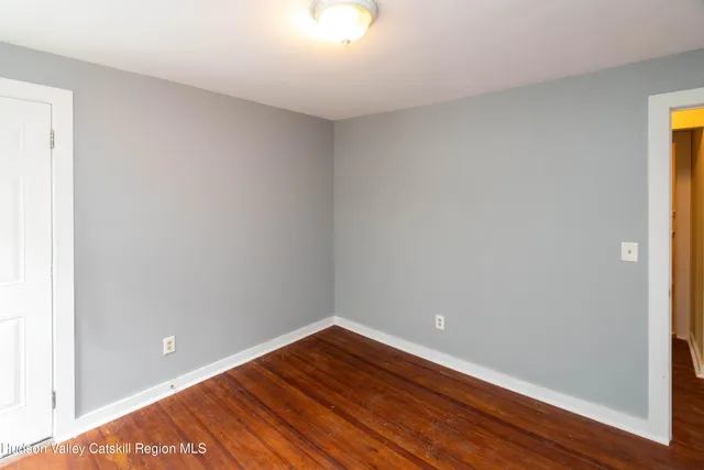 a view of an empty room with wooden floor