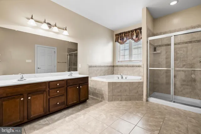 a spacious bathroom with a tub sink and mirror