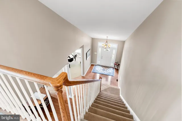a view of a hallway with wooden floor and stairs