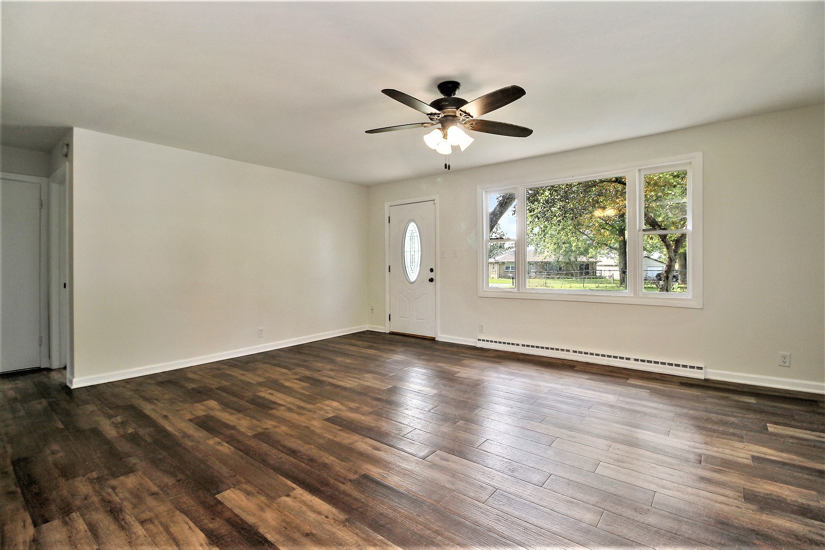 89 South 3120W Road Kankakee, IL 60901 - Photo 3 of 14 a view of an empty room with wooden floor and a window