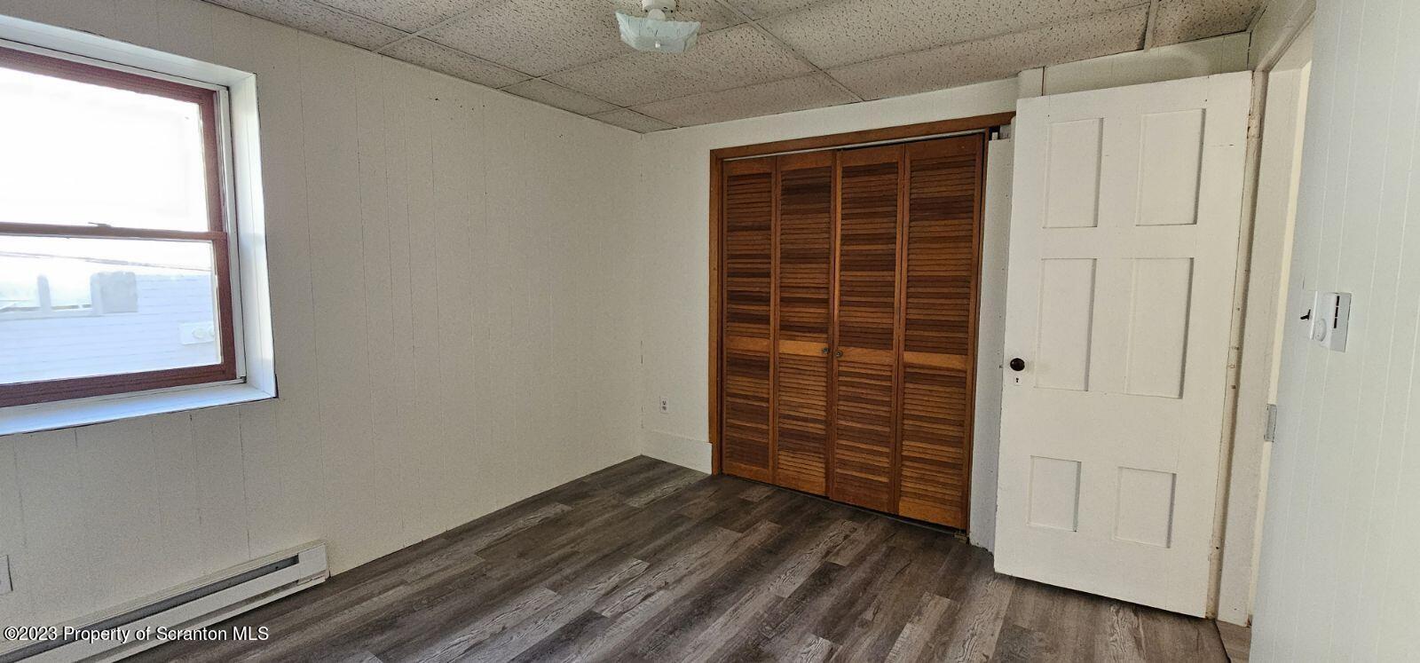 103 Warren Street, Unit 2 Tunkhannock, PA 18657 - Photo 2 of 8 an empty room with wooden floor and windows