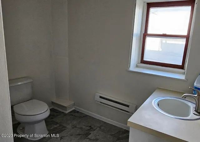 a bathroom with a toilet sink and window