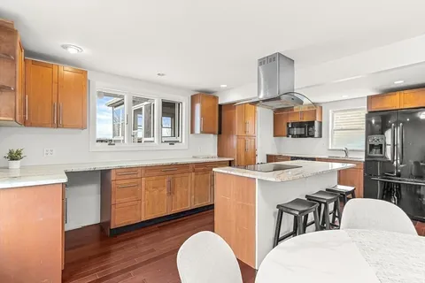 a kitchen with stainless steel appliances granite countertop a white cabinets and a stove