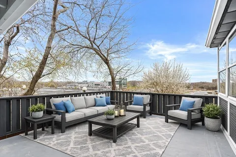 a roof deck with couches and potted plants