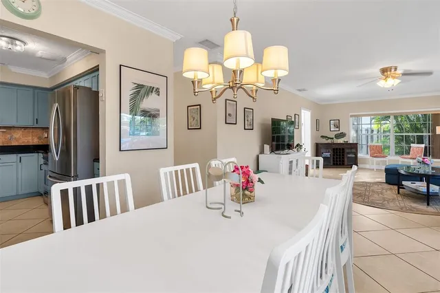 a bedroom with a bed a chandelier and mirror