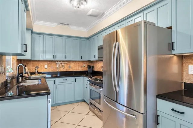 a kitchen with granite countertop a refrigerator and a sink