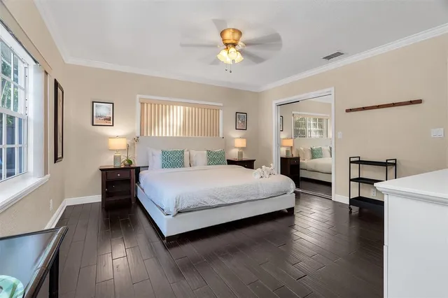 a bedroom with a large bed a chandelier and windows