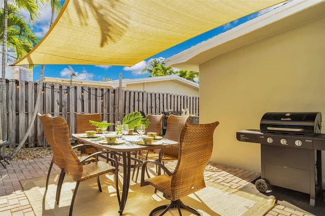 a view of a patio with a table and chairs under an umbrella
