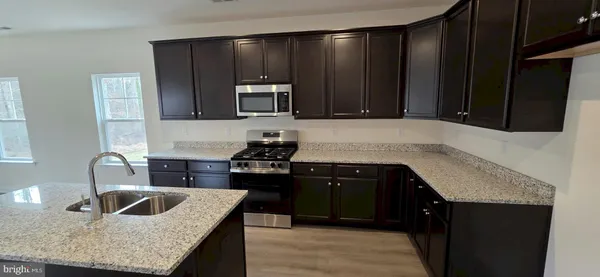 a kitchen with granite countertop a stove and a sink