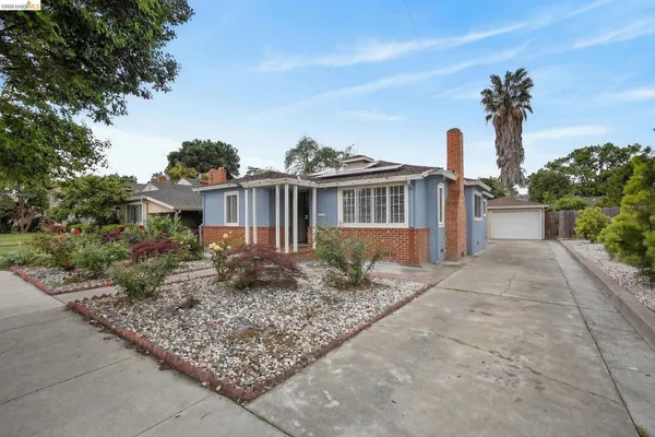 a kitchen with stainless steel appliances granite countertop a sink a stove a refrigerator cabinetry and large window