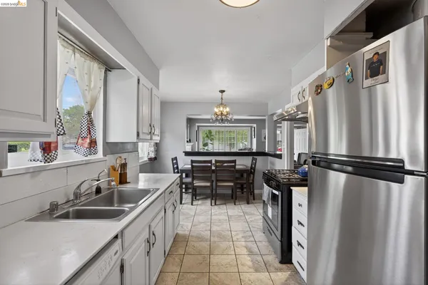 a kitchen with white cabinets stove top oven and sink