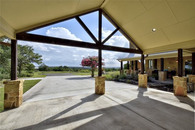 633 Trails End Road Johnson City, TX 78636 - Photo 22 of 29 An expansive covered carport features rustic timber framing alongside robust stone pillar accents.