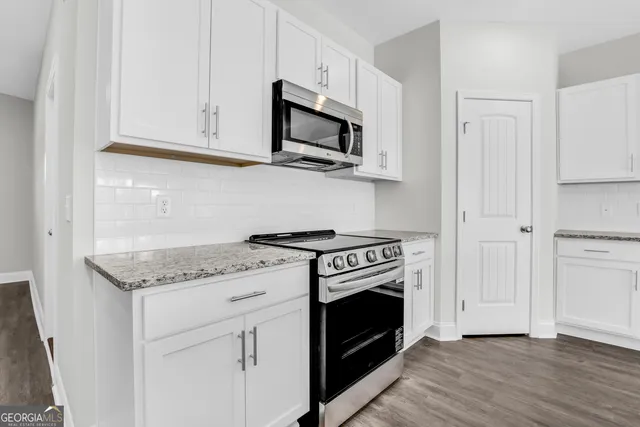a white stove top oven sitting inside of a kitchen