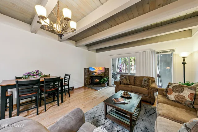 a living room with furniture a chandelier and a flat screen tv