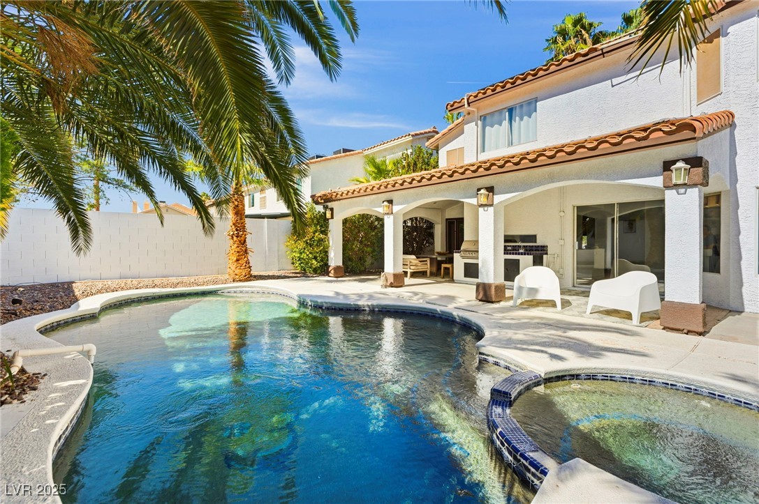 2829 Via Florentine Street Henderson, NV 89074 - Photo 20 of 48 Back of property with stucco siding, a patio area, area for grilling, a pool with connected hot tub, and a tile roof
