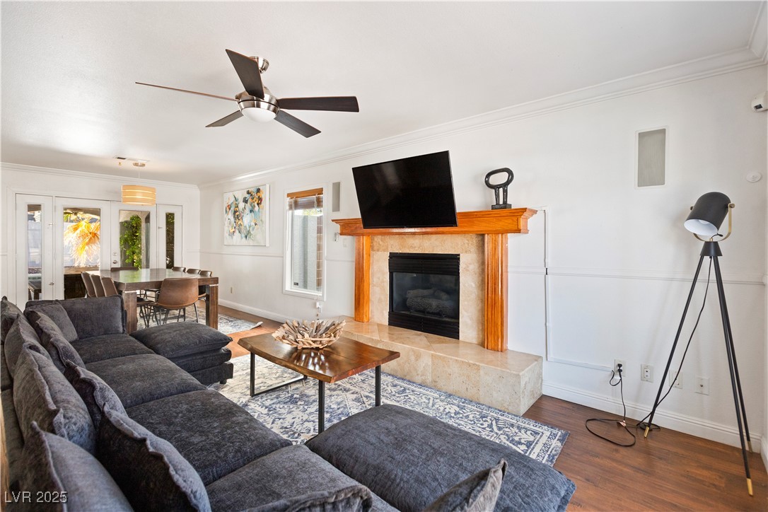 2829 Via Florentine Street Henderson, NV 89074 - Photo 29 of 48 Living area featuring ornamental molding, dark wood-style floors, a fireplace, a ceiling fan, and french doors