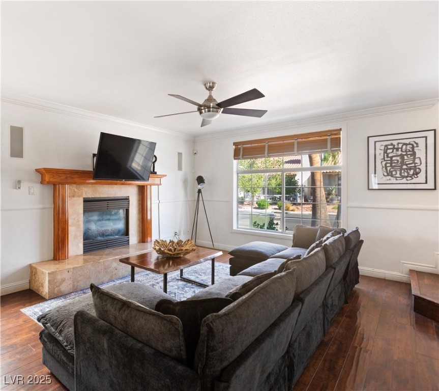 2829 Via Florentine Street Henderson, NV 89074 - Photo 31 of 48 Living room with dark wood-style floors, crown molding, a high end fireplace, and a ceiling fan