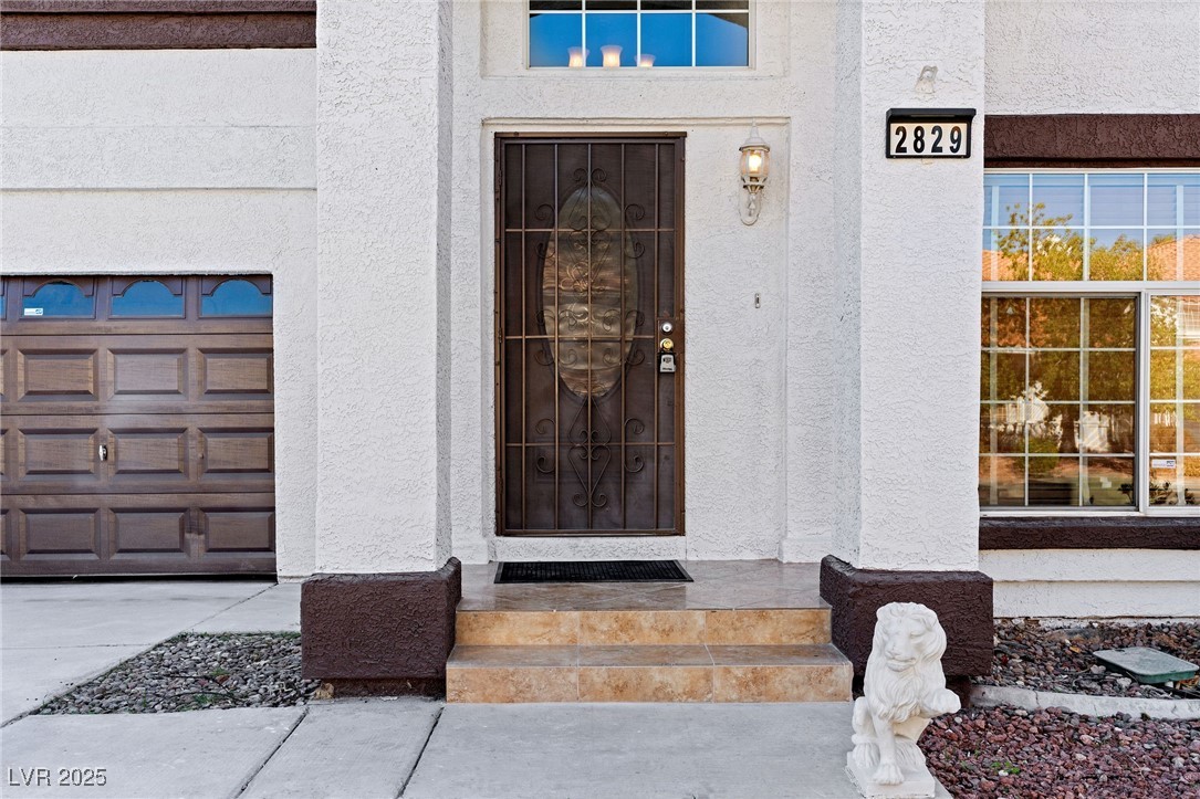 2829 Via Florentine Street Henderson, NV 89074 - Photo 32 of 48 Doorway to property featuring stucco siding and a garage