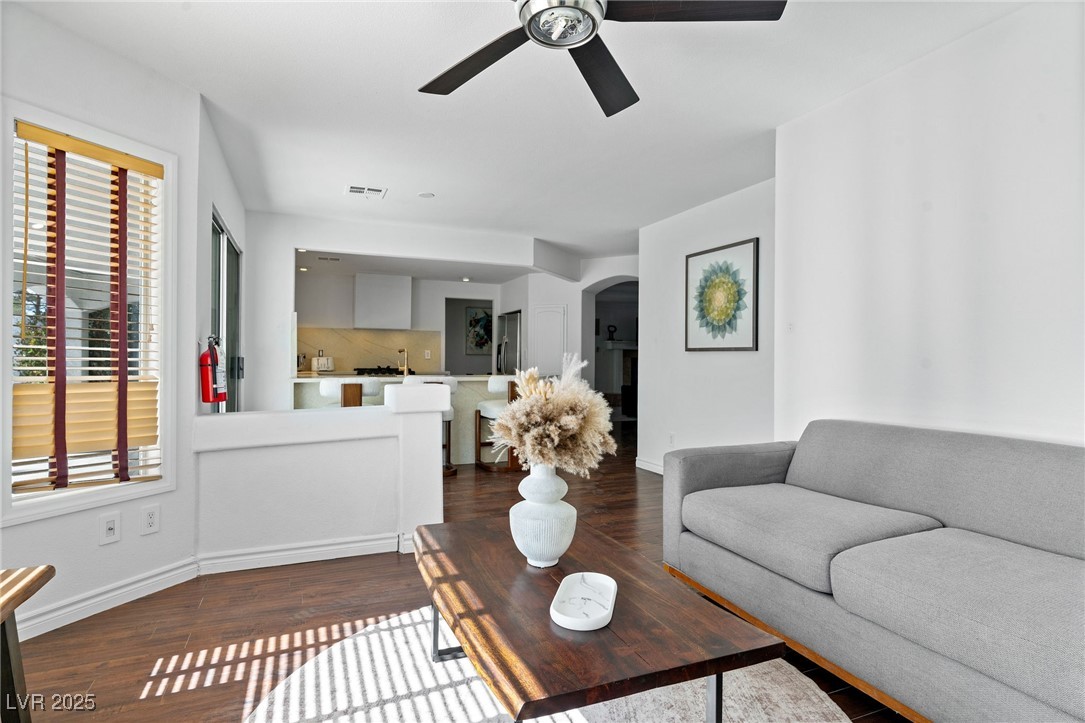 2829 Via Florentine Street Henderson, NV 89074 - Photo 43 of 48 Living room featuring arched walkways, dark wood-type flooring, and a ceiling fan