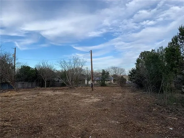 a view of a field with trees in background